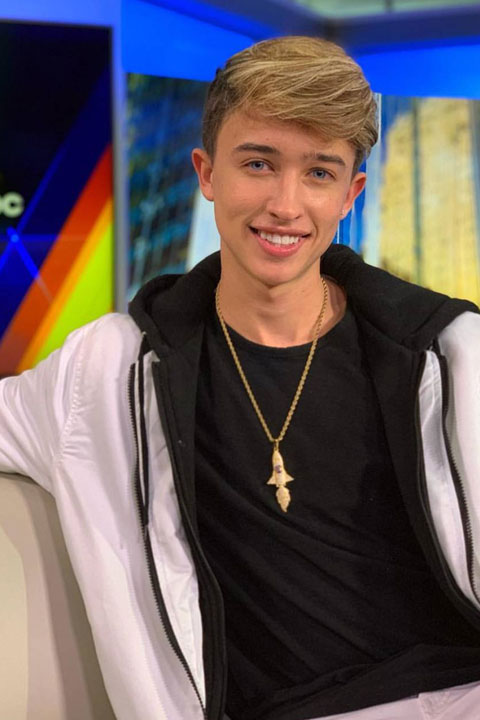 Maverick Baker in black tshirt and white jacket