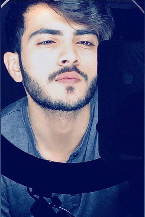 Mubeen rehmaan looking at mirror with Iphone in hand