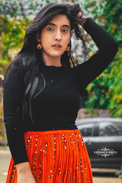 Sameeksha Sud wearing black shirt and orange long skirt