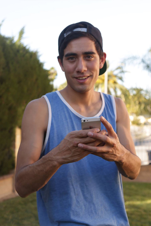 Zach King in blue vest holding I phone 6