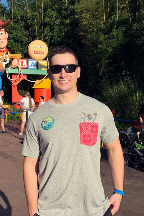 Nick Smithyman wearing grey tshirt and black sun glasses at amusement park