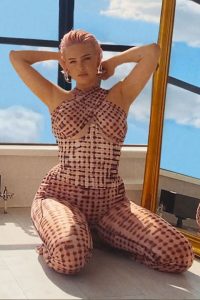Anne Marie is looking beautiful in sitting posture and wearing printed dress.