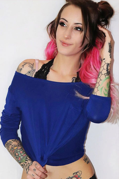 Sarah Janeczko in blue top and pink bra