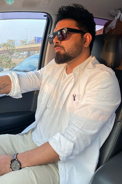 Yasir Hussain in white shirt and green dress pent