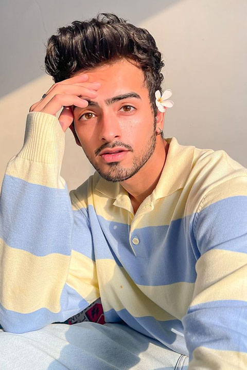 Sanket Mehta is posing for a picture in yellow and blue shirt.