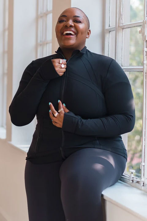 Nyome Nicholas-Williams smiling while zipping her upper