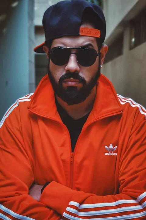 Ghazenfer Jaffery wear an orange jacket.