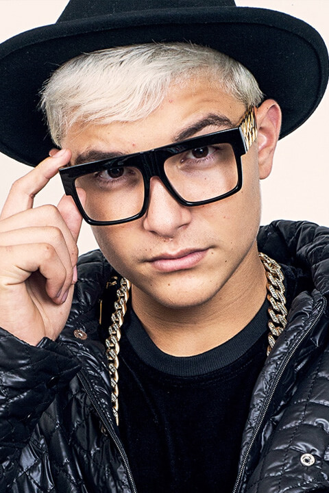 MC Gui is wearing a black cap and glasses.